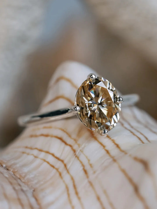 white gold yellow moissanite ring on sea shell